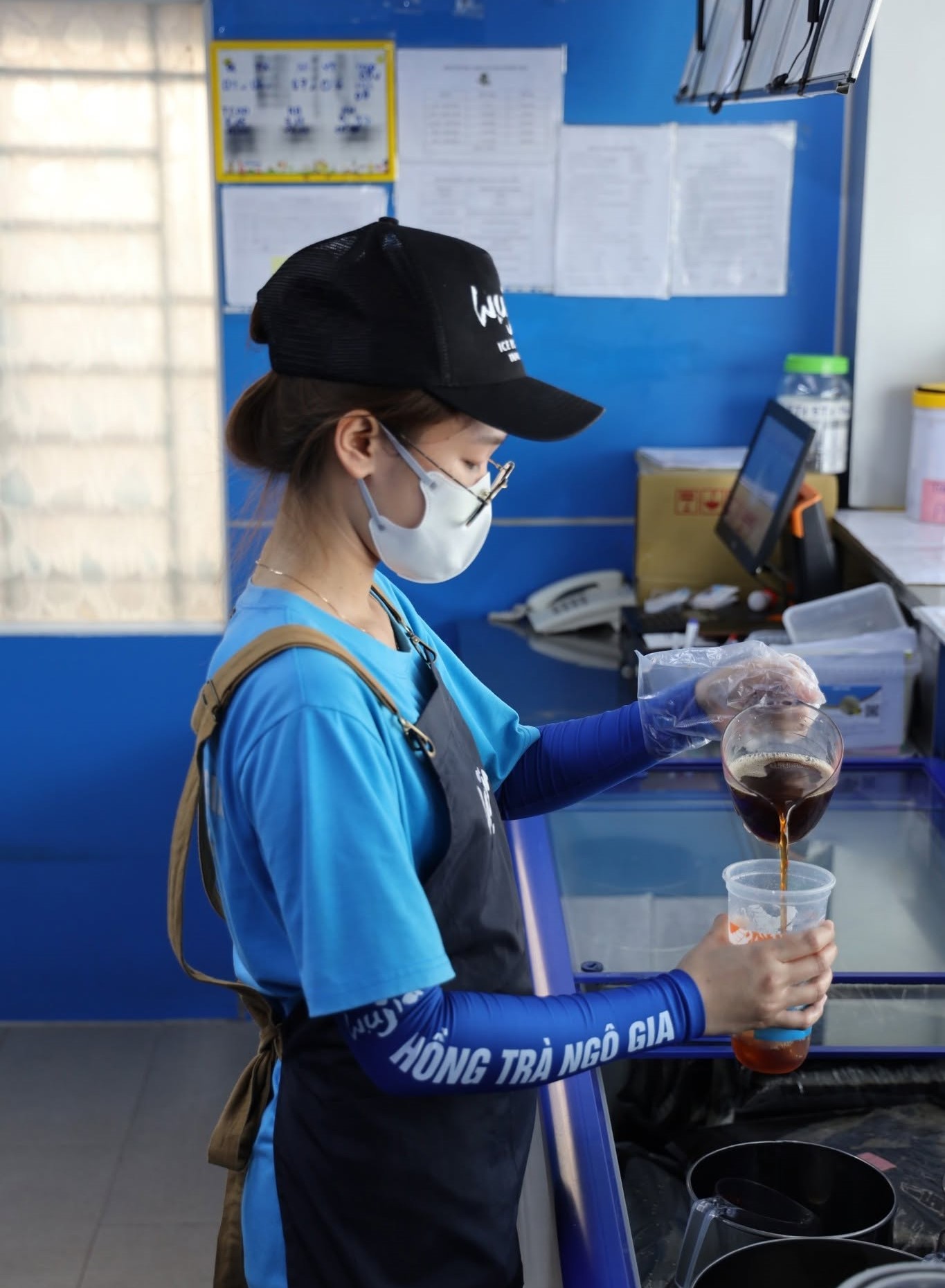 Staff crafting customized iced milk tea and boba drinks at a busy counter